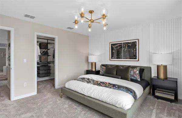 a bedroom with a large bed and a chandelier