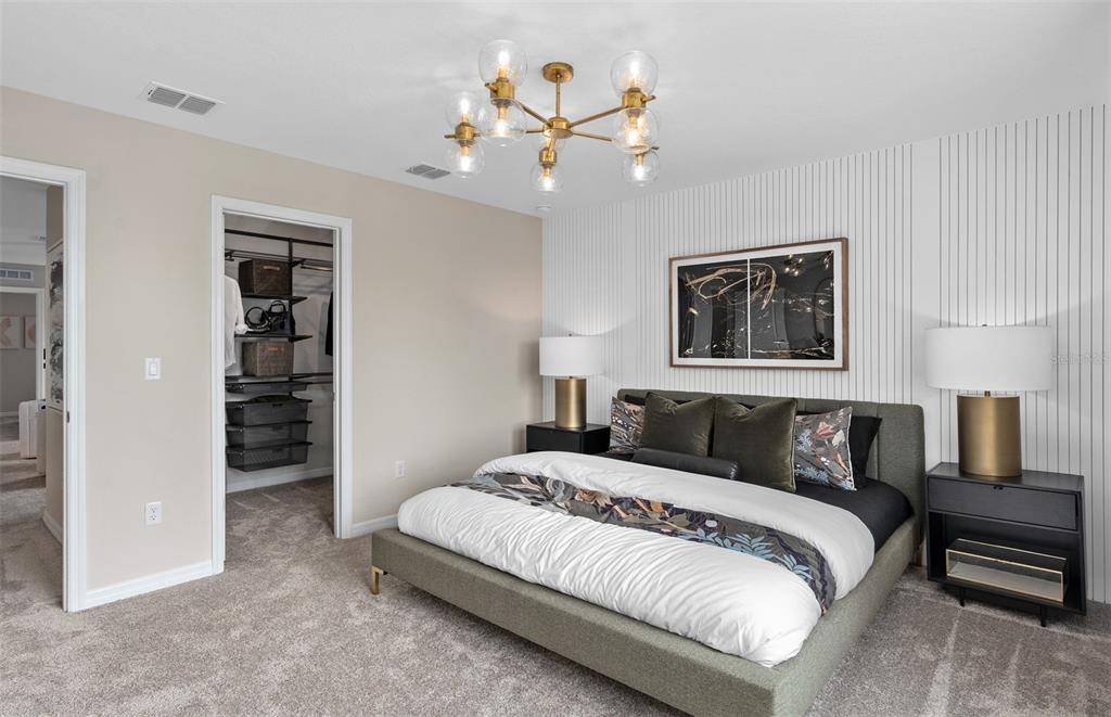 5013 Furrowed Way St. Cloud, FL 34771 - Photo 16 of 26 a bedroom with a large bed and a chandelier