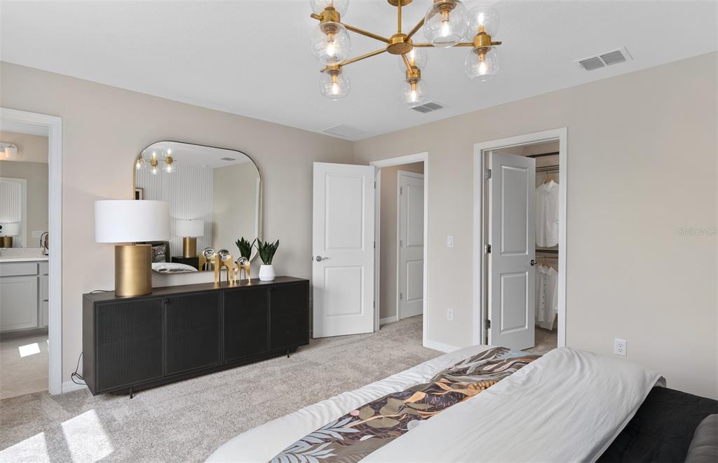 5013 Furrowed Way St. Cloud, FL 34771 - Photo 17 of 26 a bedroom with a bed and a chandelier