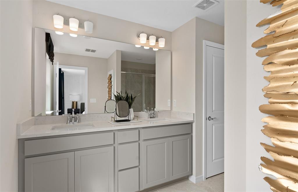 5013 Furrowed Way St. Cloud, FL 34771 - Photo 18 of 26 a bathroom with a double vanity sink and a mirror