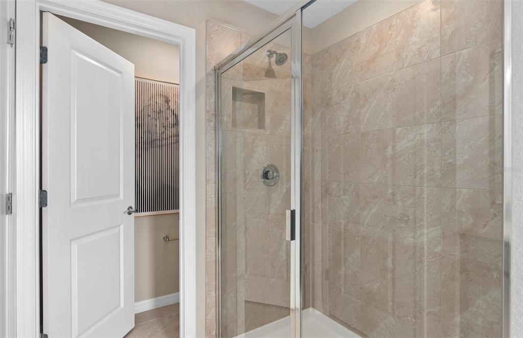 5013 Furrowed Way St. Cloud, FL 34771 - Photo 19 of 26 a bathroom with a glass shower door