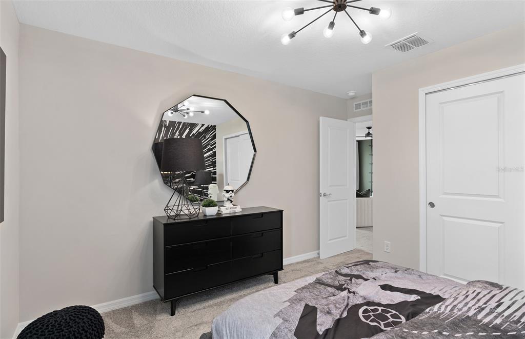 5013 Furrowed Way St. Cloud, FL 34771 - Photo 25 of 26 a bedroom with a bed and a mirror