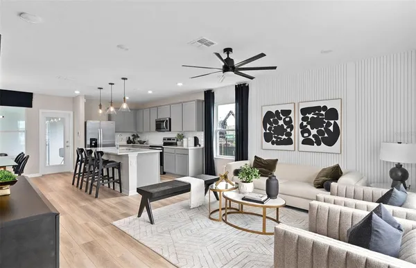 a living room with furniture kitchen view and a chandelier