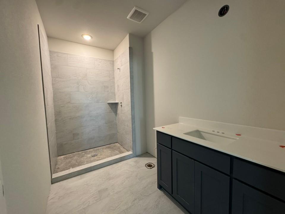 2209 Continent Court Krum, TX 76249 - Photo 21 of 24 a bathroom with a granite countertop sink a toilet and shower
