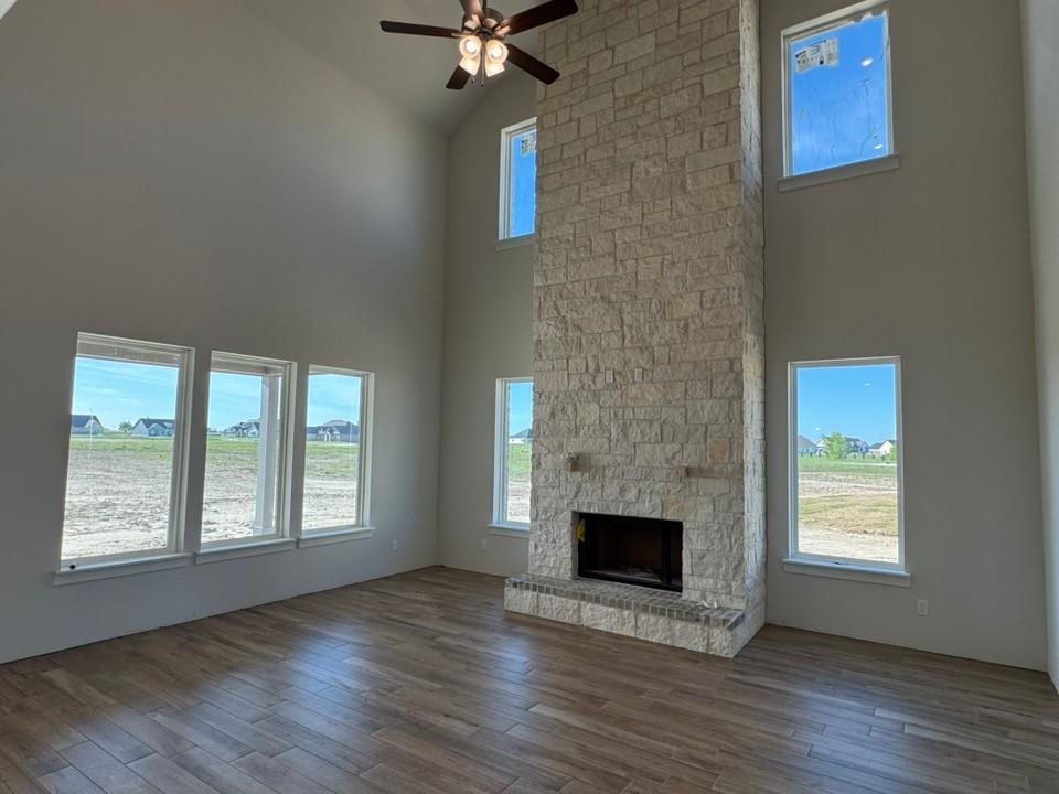 2209 Continent Court Krum, TX 76249 - Photo 9 of 24 an empty room with wooden floor a fireplace and windows