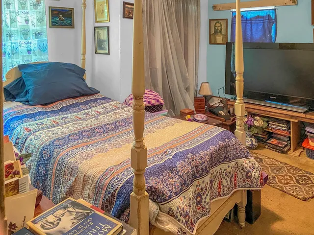 a bedroom with furniture and a flat screen tv