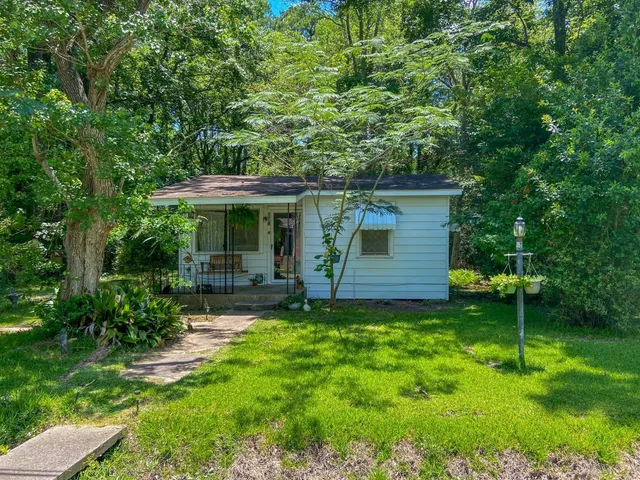 a view of a chair and table in backyard of the house