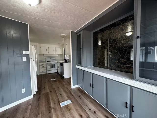 a kitchen with a refrigerator and wooden floor