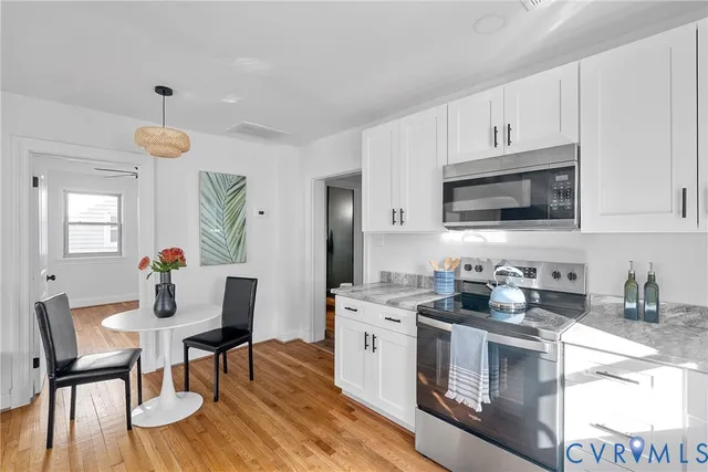 a kitchen with a dining table chairs and white cabinets