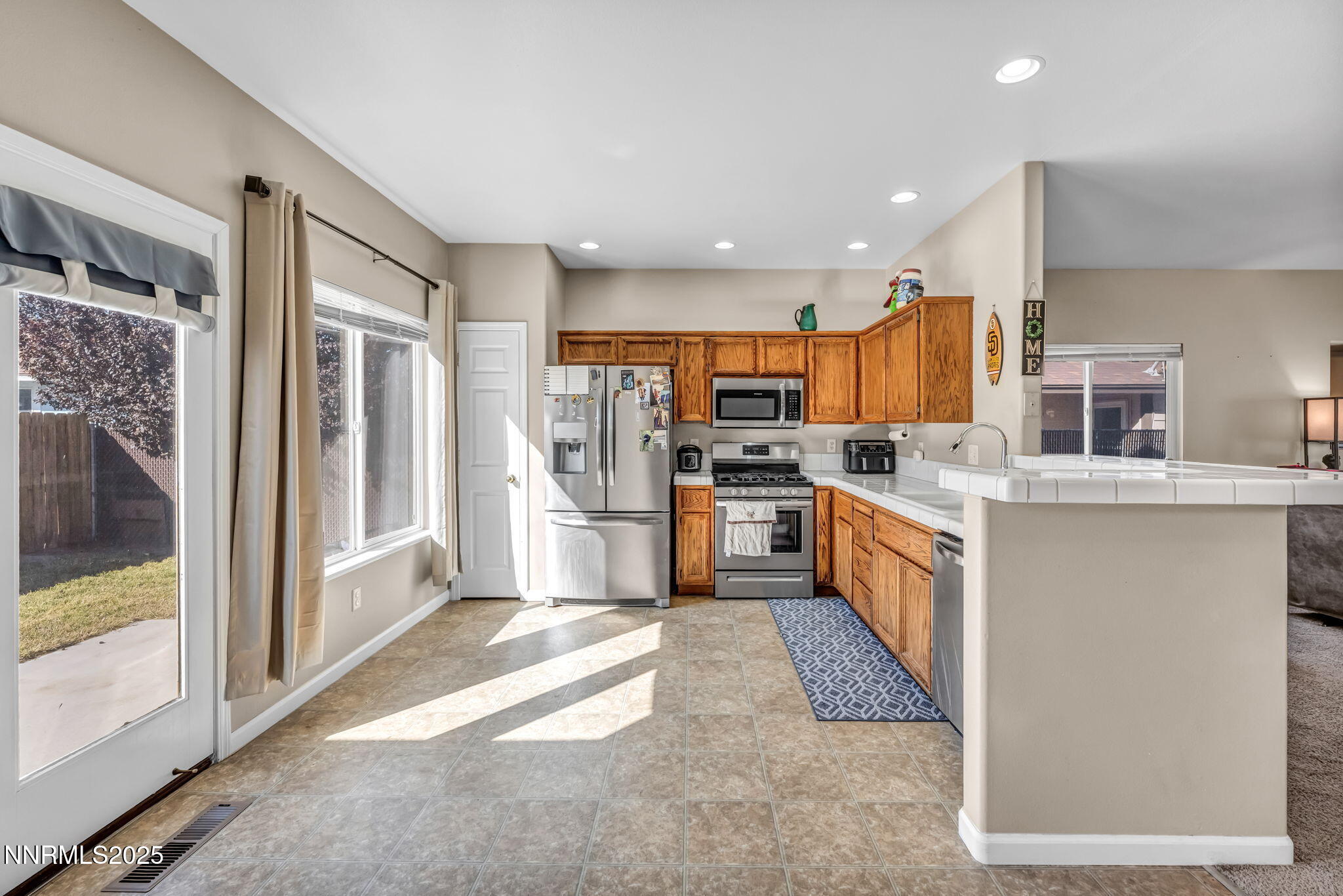 1295 Eider Circle Fallon, NV 89406 - Photo 10 of 37 a large kitchen with stainless steel appliances kitchen island granite countertop a refrigerator and a stove top oven
