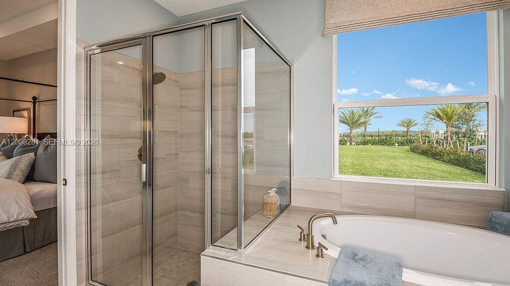 653 Southeast Ranch Oak Circle Port St. Lucie, FL 34984 - Photo 18 of 43 a bathroom with a bathtub and a shower