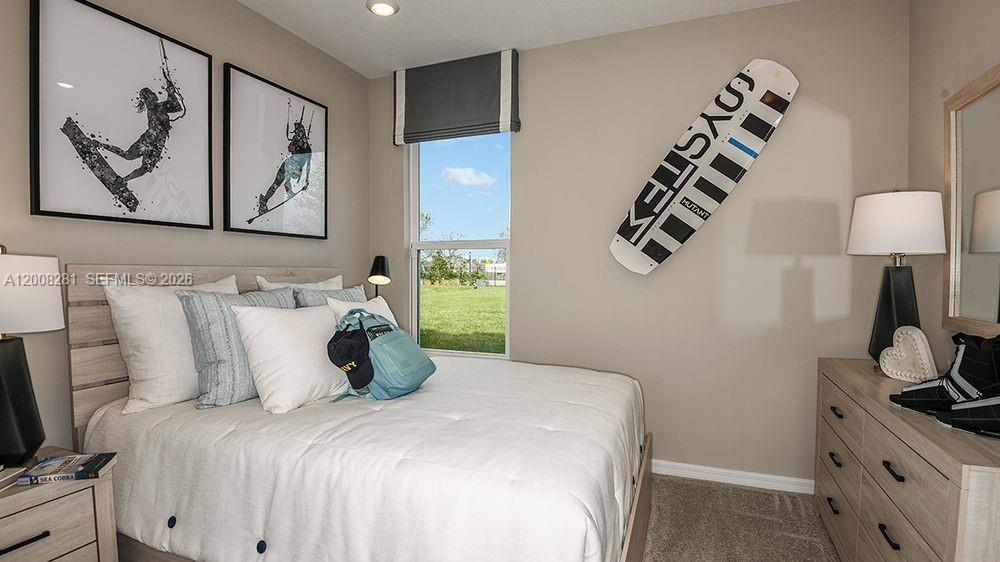 653 Southeast Ranch Oak Circle Port St. Lucie, FL 34984 - Photo 23 of 43 a bedroom with a bed and a lamp