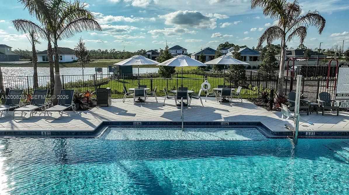 653 Southeast Ranch Oak Circle Port St. Lucie, FL 34984 - Photo 41 of 43 a view of a patio with table and chairs potted plants and palm tree