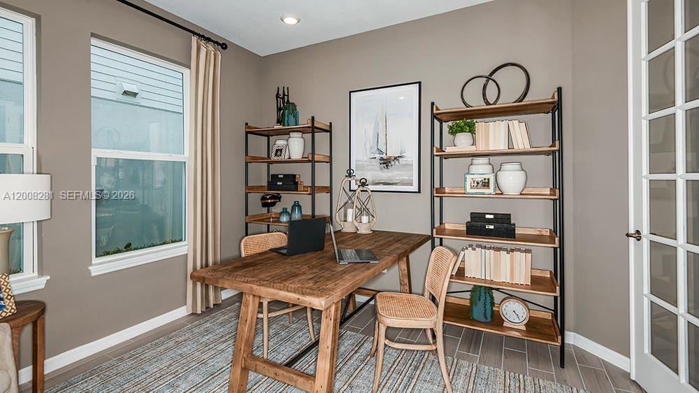 653 Southeast Ranch Oak Circle Port St. Lucie, FL 34984 - Photo 6 of 43 a view of a dining room with furniture window and wooden floor