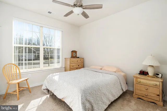 a spacious bedroom with a bed a table and chair