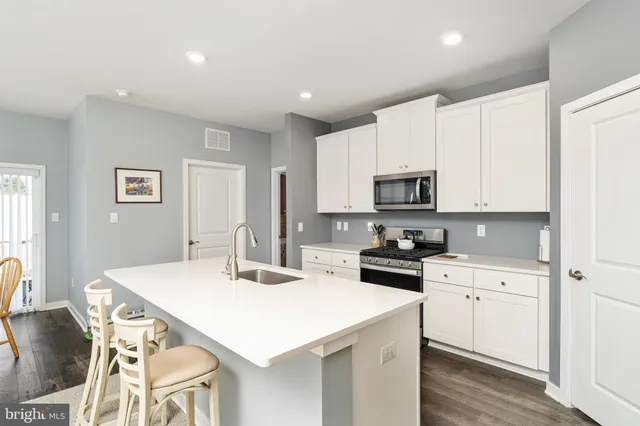 a kitchen with granite countertop white cabinets and stainless steel appliances