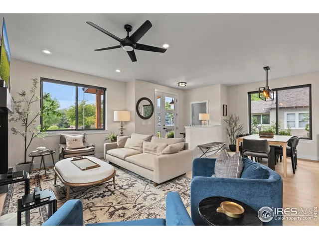 a living room with couches a dining table and a dining table with wooden floor