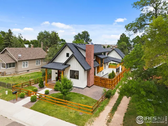 a view of a house with a small yard and large tree