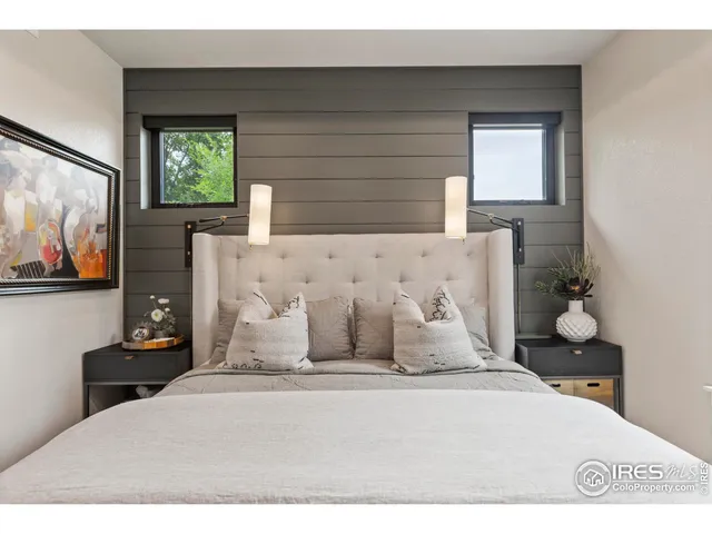 a bedroom with a bed and a painting on the wall