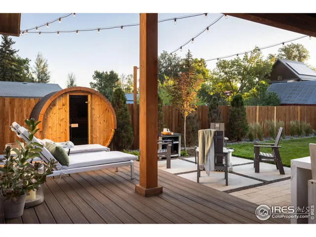 a view of backyard with potted plants and wooden fence