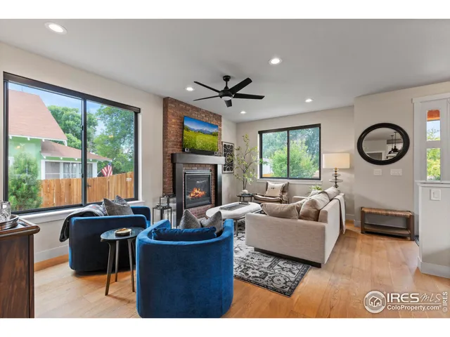 a living room with furniture a fireplace and a large window