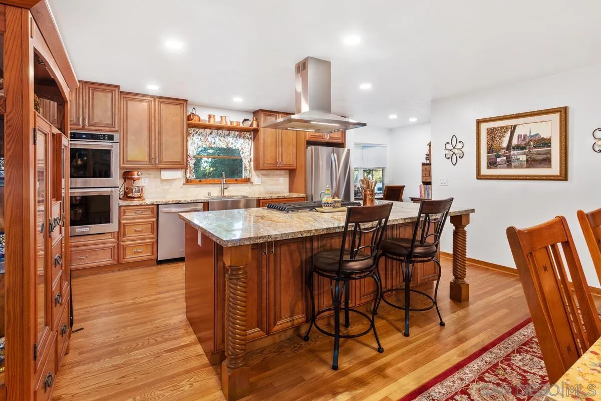 1675 Chase Lane El Cajon, CA 92020 - Photo 12 of 32 a kitchen with stainless steel appliances a dining table chairs and a refrigerator