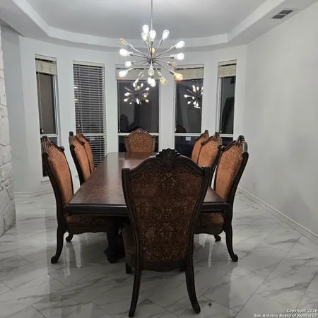 a view of a dining room with furniture and chandelier