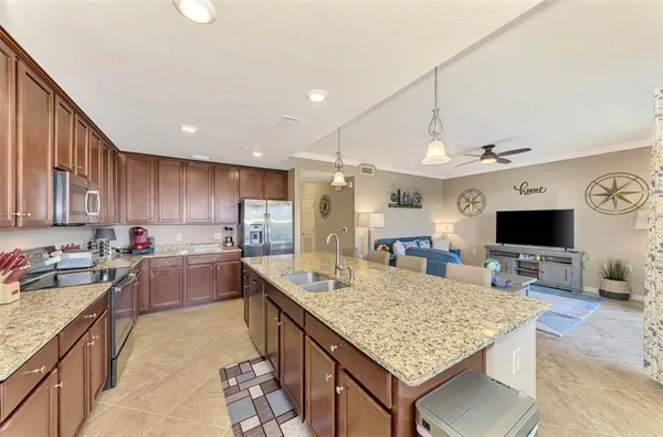 a kitchen with kitchen island granite countertop a sink counter top space appliances and cabinets