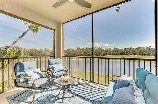 a balcony with wooden floor table and chairs