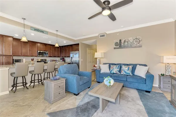 a living room with furniture kitchen view and a chandelier