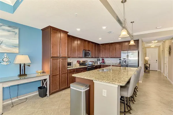 a kitchen with stainless steel appliances granite countertop a sink refrigerator and cabinets