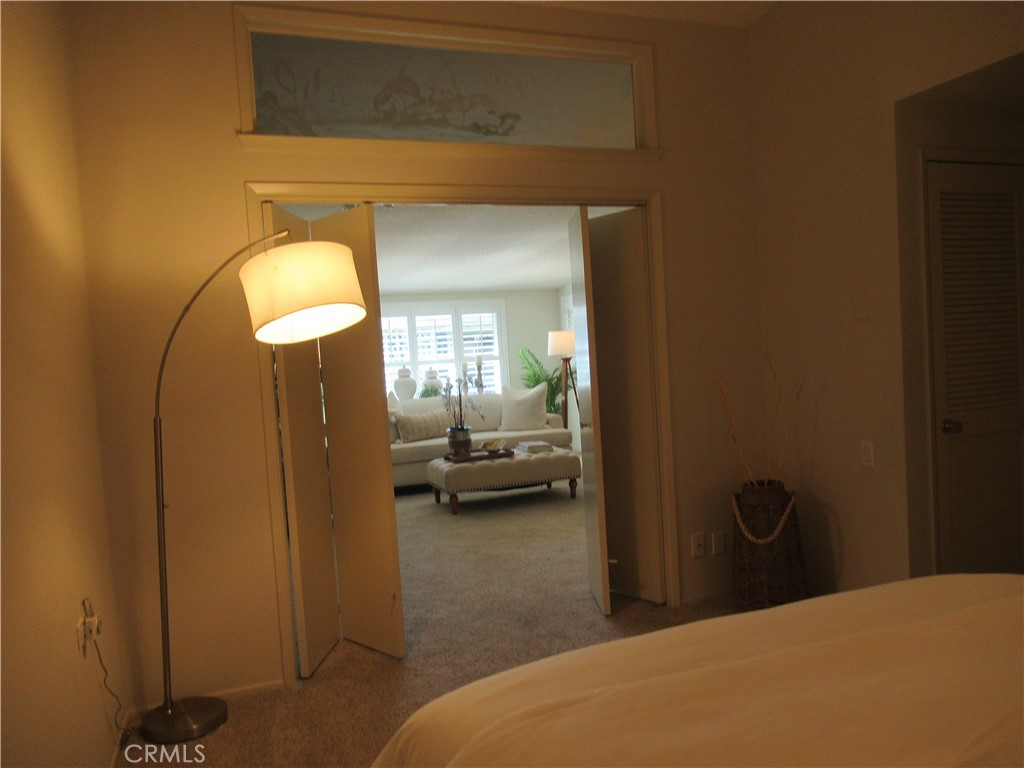 1230 Scioto Road Seal Beach, CA 90740 - Photo 15 of 27 a bedroom with a bed and a chandelier