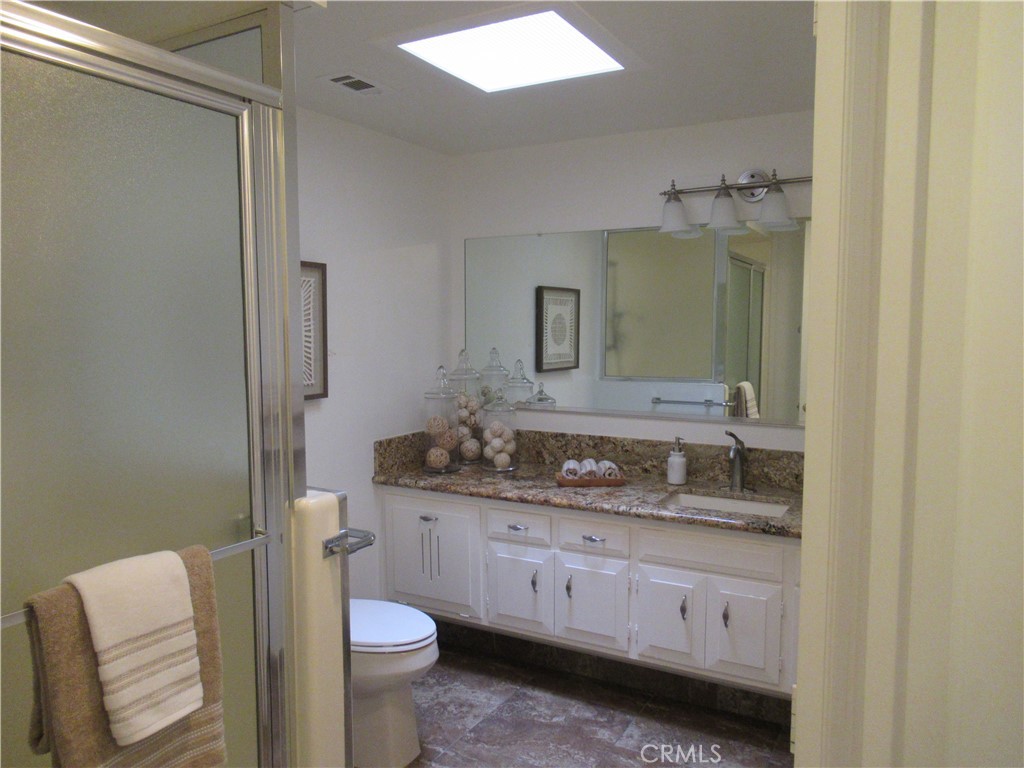 1230 Scioto Road Seal Beach, CA 90740 - Photo 27 of 27 a bathroom with a granite countertop toilet sink and mirror