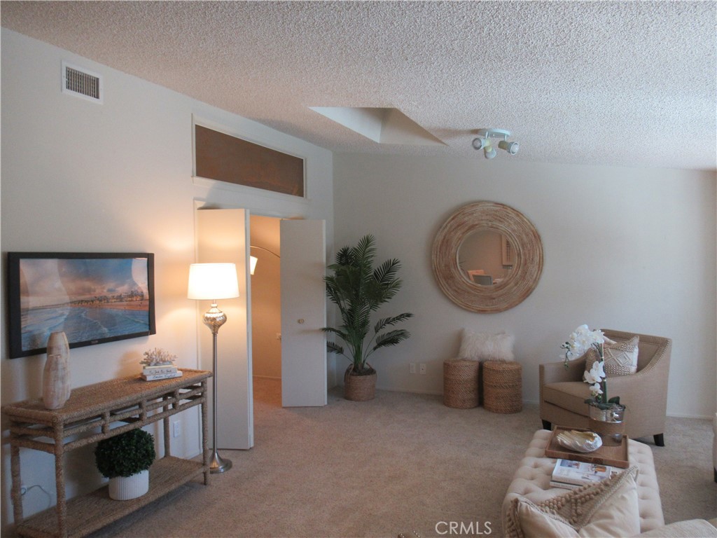 1230 Scioto Road Seal Beach, CA 90740 - Photo 10 of 27 a living room with furniture a flat screen tv and a wall clock