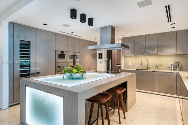 a kitchen with kitchen island a stove a table and chairs in it