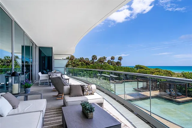 a view of a balcony with dining table and chairs