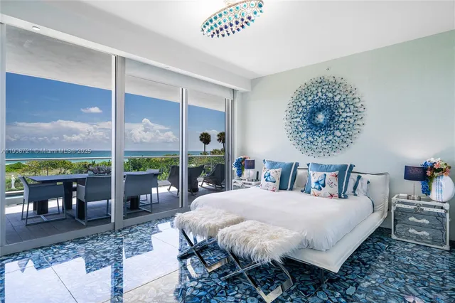 a bedroom with a bed table and a large window