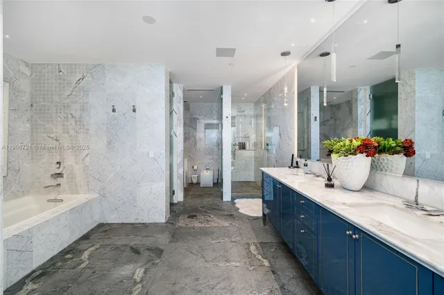 a bathroom with a granite countertop sink mirror and a bathtub