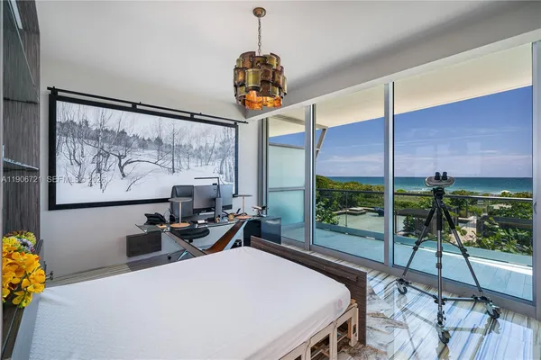 a bedroom with a bed a large window with table and chairs