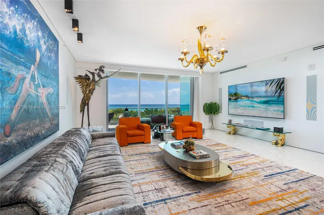 a living room with furniture and a chandelier