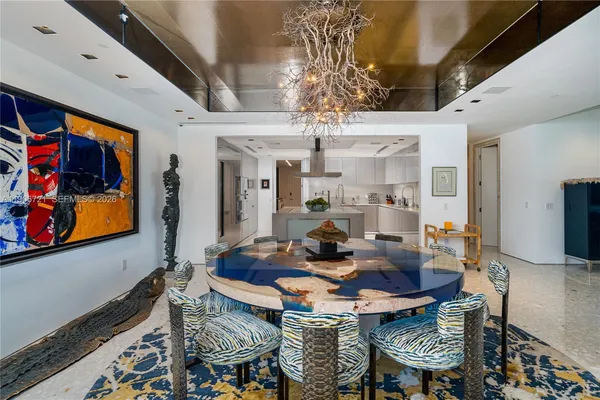 a view of a dining room with furniture a chandelier and wooden floor