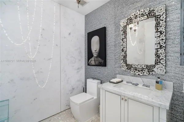 a bathroom with a granite countertop sink toilet and mirror