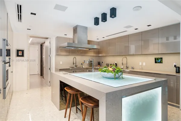 a kitchen with a sink a stove and chairs