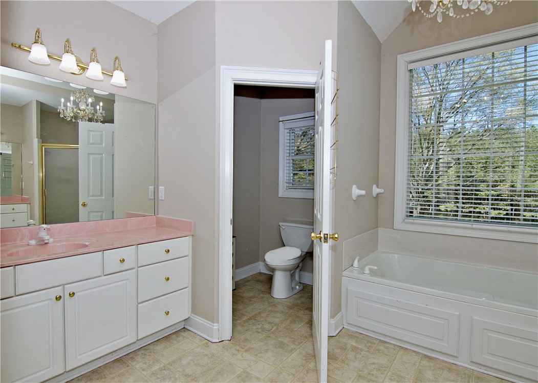 7893 Athens Road Carnesville, GA 30521 - Photo 20 of 50 Bright and airy, this bathroom offers a functional layout with a large vanity and a spacious tub.