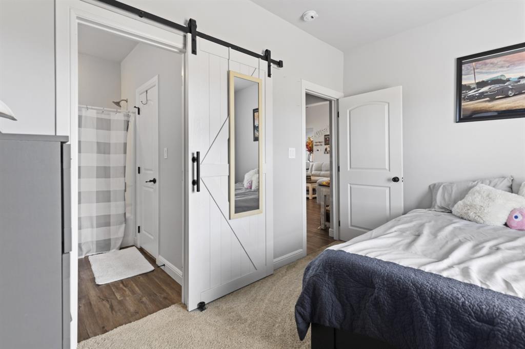 1195 Hog Town Road Collinsville, TX 76233 - Photo 15 of 37 a bedroom with a bed and a glass door shower