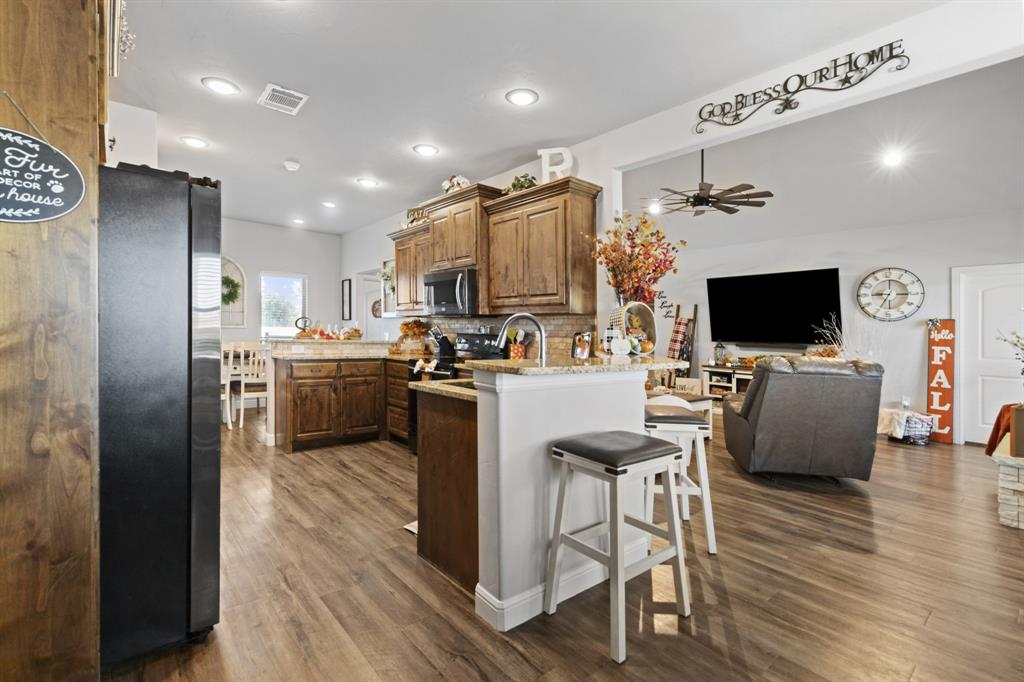 1195 Hog Town Road Collinsville, TX 76233 - Photo 8 of 37 a living room with stainless steel appliances furniture and a flat screen tv