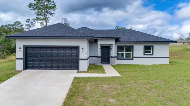 a front view of a house with yard and garage