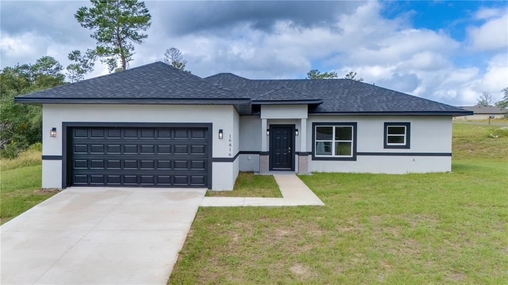 16816 Southwest 41st Avenue Road Ocala, FL 34473 - Photo 1 of 21 a front view of a house with yard and garage