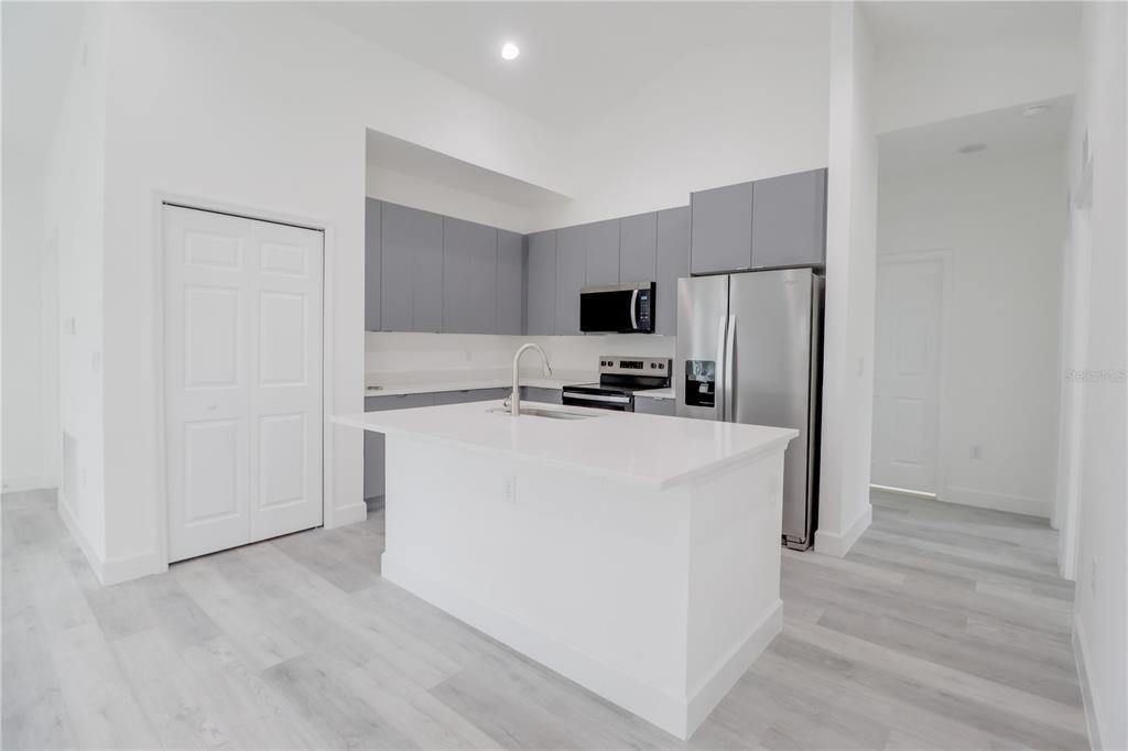 16816 Southwest 41st Avenue Road Ocala, FL 34473 - Photo 9 of 21 a kitchen with kitchen island a white counter top space stainless steel appliances and cabinets