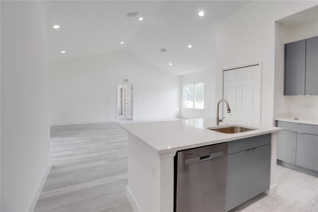 16816 Southwest 41st Avenue Road Ocala, FL 34473 - Photo 10 of 21 a kitchen with a sink dishwasher and a stove with wooden floor